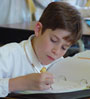 Young boy leaning over his book